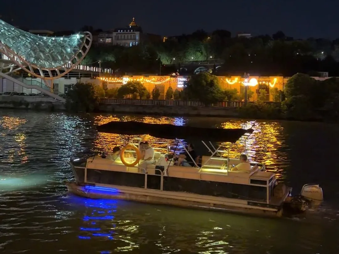 Boat ride past Peace Bridge at night