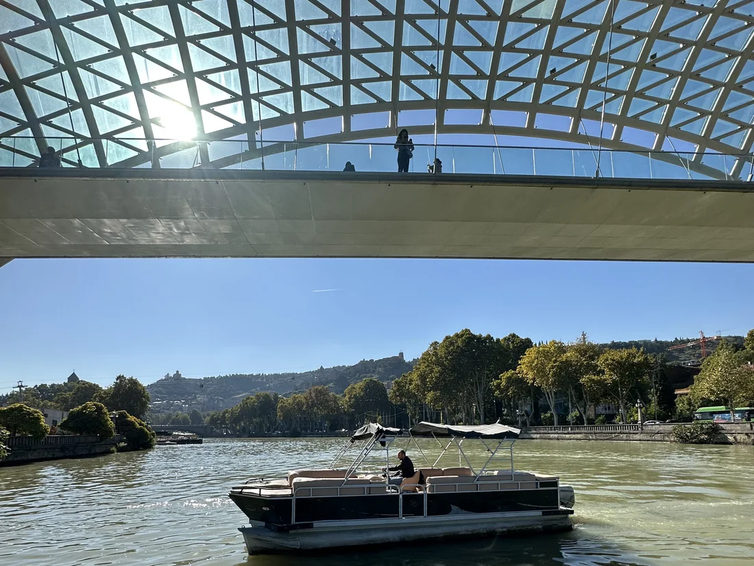 View of the Kura river from under the glass canopy of Peace Bridge